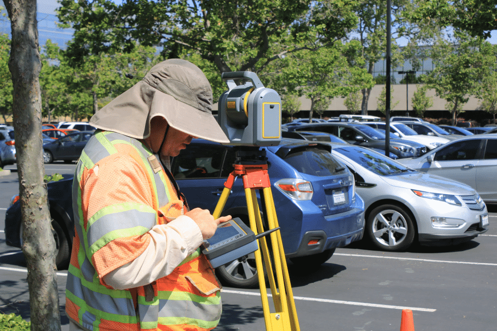 Topographic surveyor in parking lot