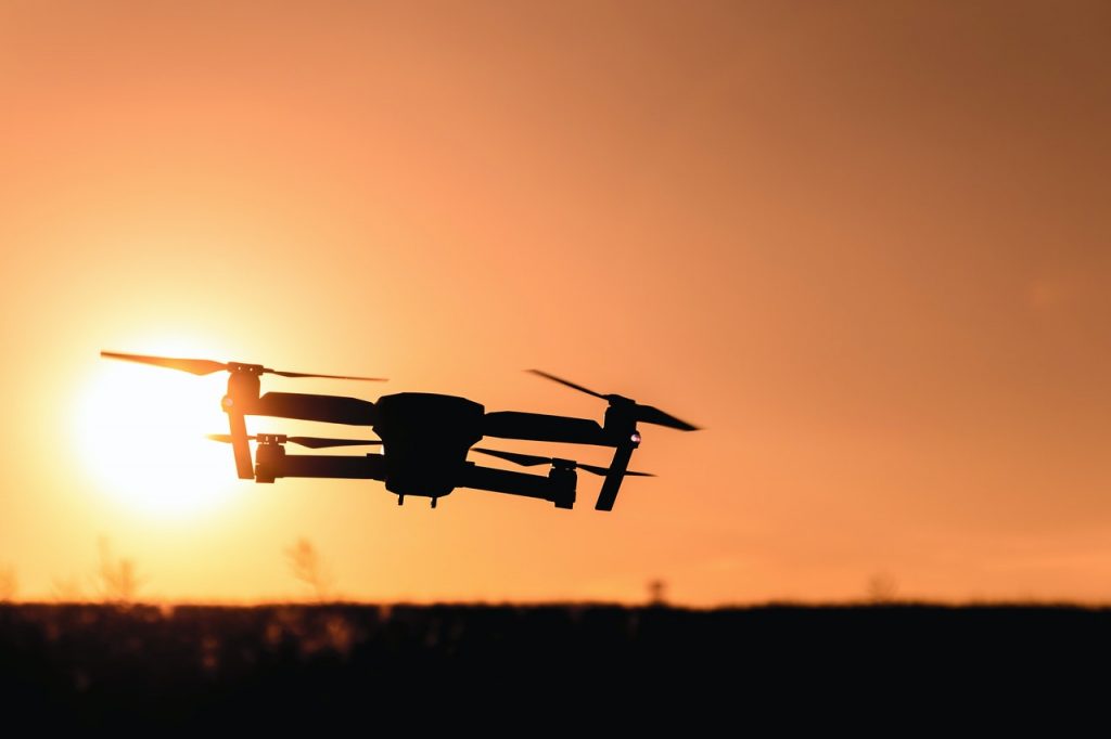 a drone flying in a sunset