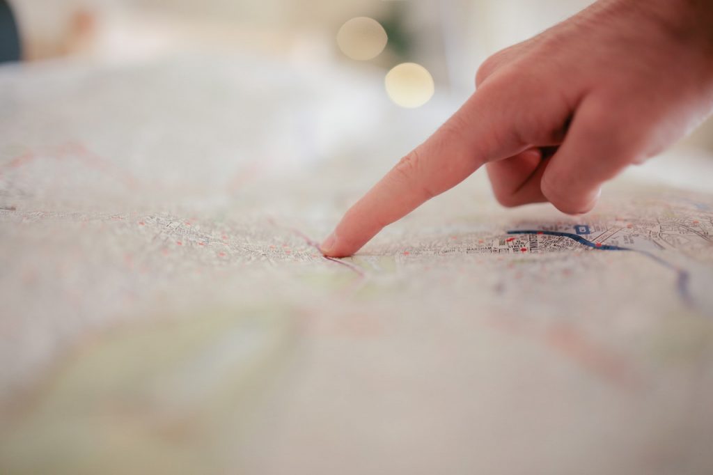 person poitning a finger at a map