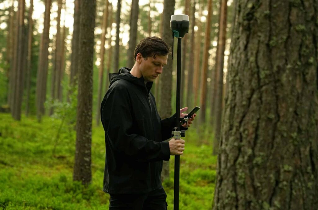 a New York land surveyor outside using a land survey tool