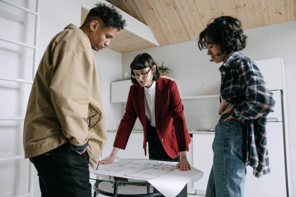 a couple evaluating blueprints of a property