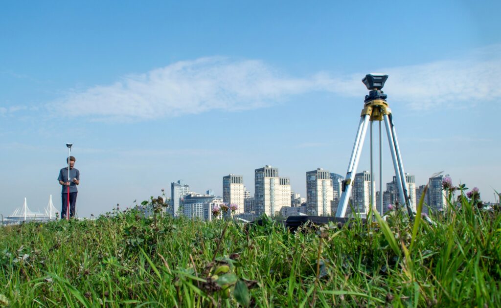 A man surveys with tools, illustrating the importance of accurate land surveying