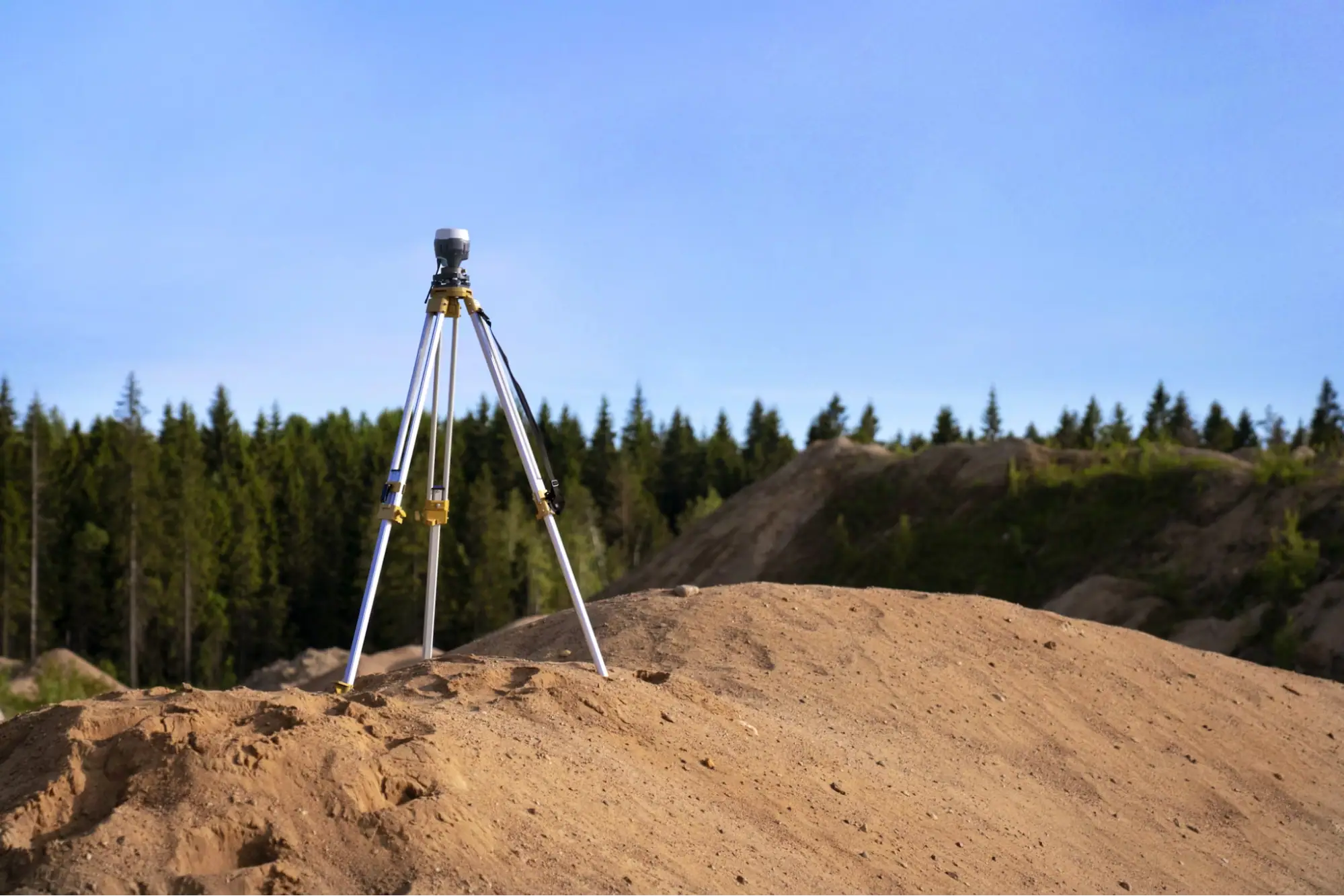 steel tripod on brown hill