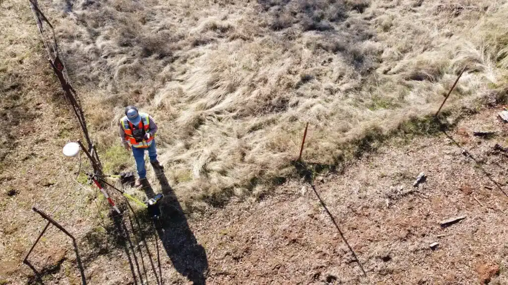 bird’s eye view shot of a man in neon vest standing on dry field