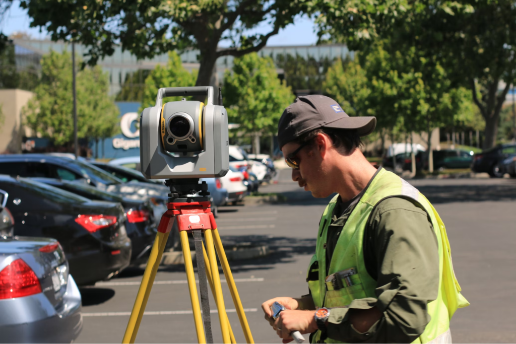 man standing facing theodolite