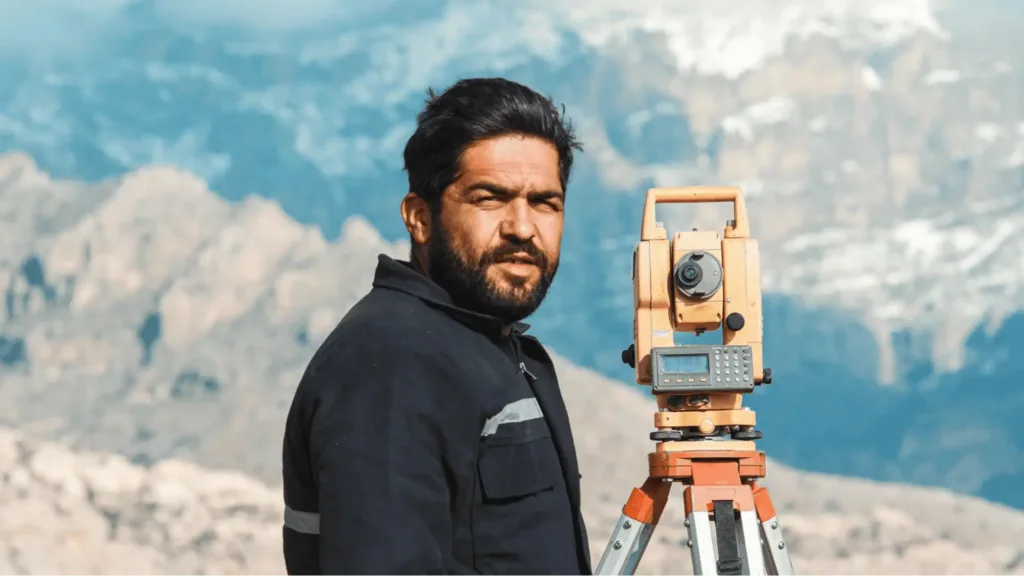 surveyor in mountainous terrain with equipment