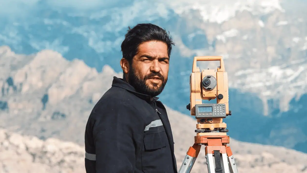 surveyor in mountainous terrain with equipment
