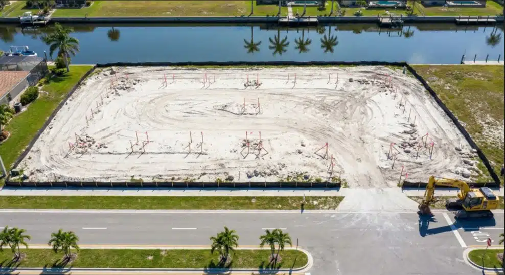 Aerial view of commercial development site in Cape Coral with survey markers and equipment